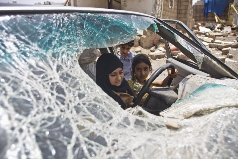 Yemeni girls play with a vehicle damaged by Saudi-led coalition airstrikes in Sanaa, Yemen, Monday, May 18, 2015. Saudi-led airstrikes targeting Yemen's Shiite rebels resumed early on Monday in the southern port city of Aden after a five-day truce expired amid talks on the war-torn country's future that were boycotted by the rebels. 