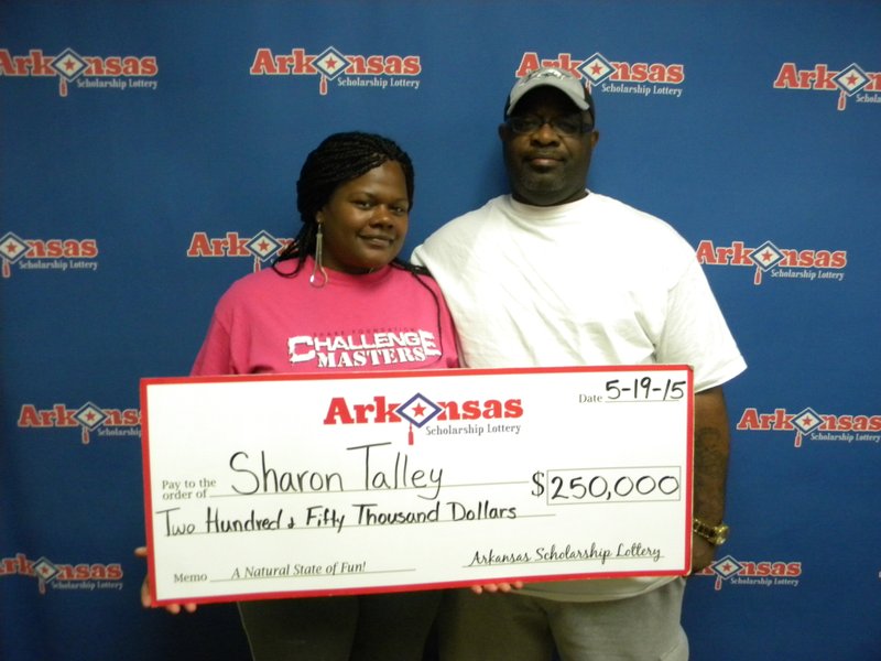 Sharon Talley, pictured with her husband Robert, shows off her $250,000 winnings from the Arkansas Scholarship Lottery on Tuesday, May 19, 2015. 
