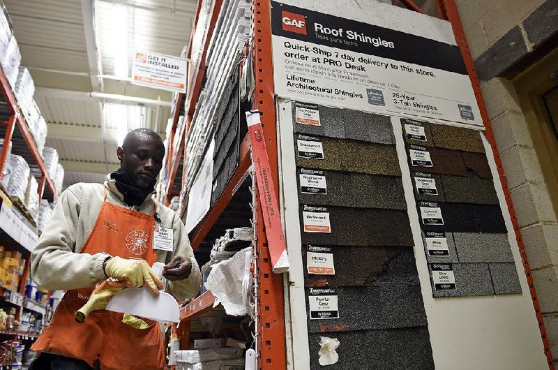 Prince Addy of Manassas, Va., straightens up shelves of roofing products at the Home Depot in Falls Church, Va., in late February. 