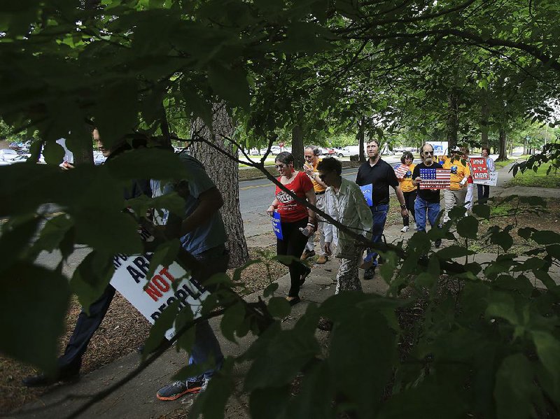 Demonstrators march along Commerce Street in Little Rock on Tuesday on their way to the state Capitol. They rallied in favor of greater restrictions on campaign spending. 