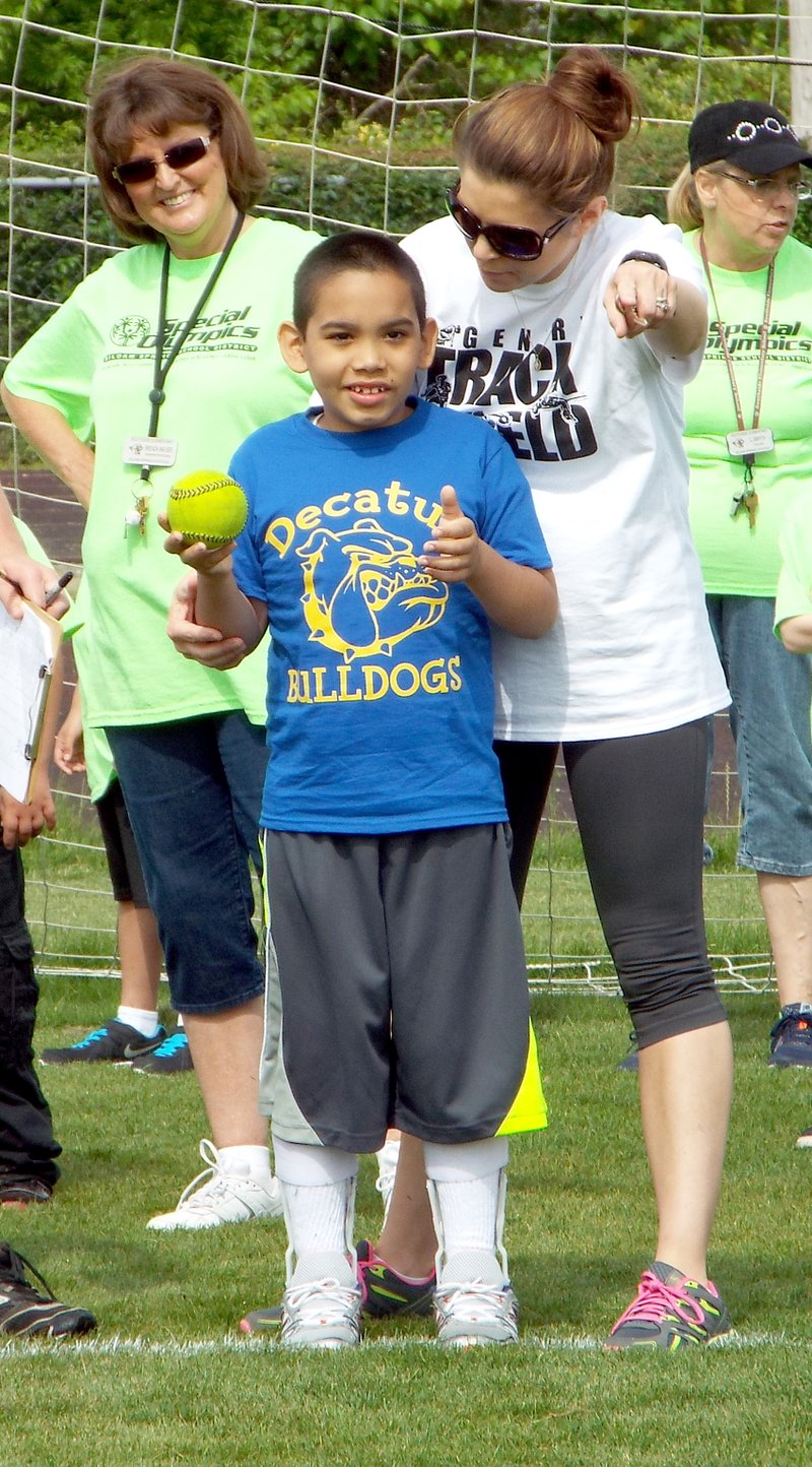 Photo by Randy Moll Andrew Ruiz of Decatur, with the help of staff, participated in the softball throw during the special education track and field event held Friday at Gentry High School.