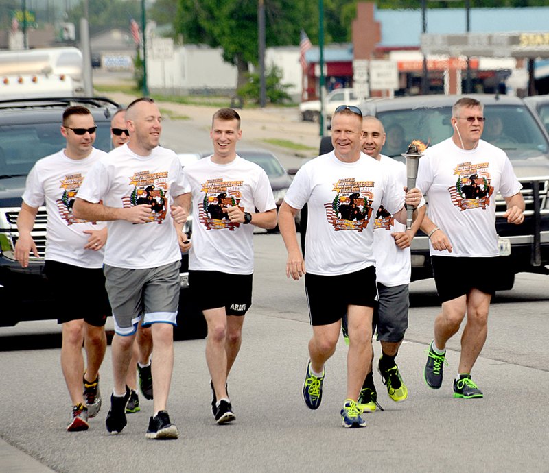 Janelle Jessen/Herald-Leader Seven Siloam Springs police officers participated in the annual Special Olympics Torch Run on Monday morning. The runners carried the torch from the state line, down U.S. Highway 412 to the city limits, where they passed it on to officers from the Arkansas Highway Patrol and deputies from the Benton County Sheriff&#8217;s Office. Pictured, from left, is patrol officer James McFerron, sergeant Todd Brakeville, corporal Stephen Deppner, patrol officer Josh Fritz, sergeant James Hodge, patrol officer Emmanuel Flores and Chief Jim Wilmeth.