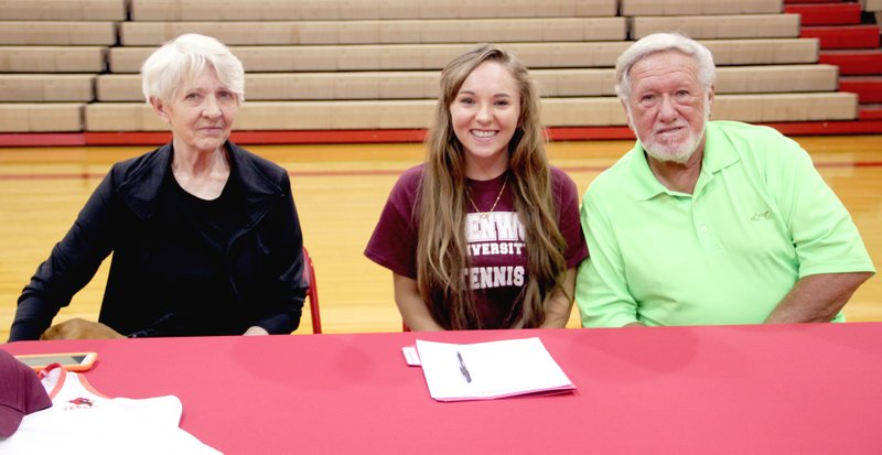 LYNN KUTTER ENTERPRISE-LEADER Farmington High School senior Teah Flynn flanked by her grandparents, Daun Flynn and George Schmitt, who raised her, signed to play tennis for Lindenwood University in Belleville, Ill., at Farmington&#8217;s Mryl Massie Gymnasium on May 4. She is also among 10 Arkansas high school seniors selected as recipients of a $1,000 college scholarship from Centennial Bank.