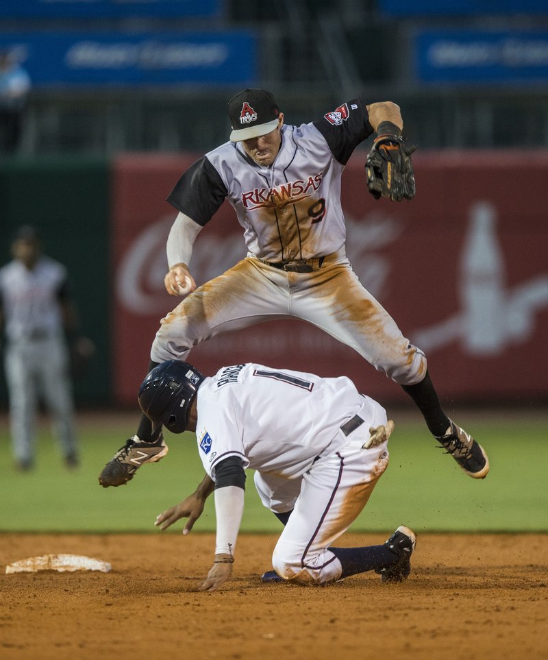 Angel Franco of the Naturals breaks up the double play as Drew Maggi, Travelers’ shortstop, is forced to leap over him during Tuesday’s game at Arvest Ballpark in Springdale.