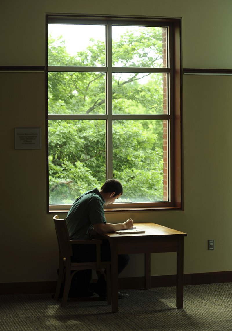 James Harter of Fayetteville studies Tuesday near a window at the Fayetteville Public Library. Harter has been spending much of his days preparing for the Medical College Admission Test.