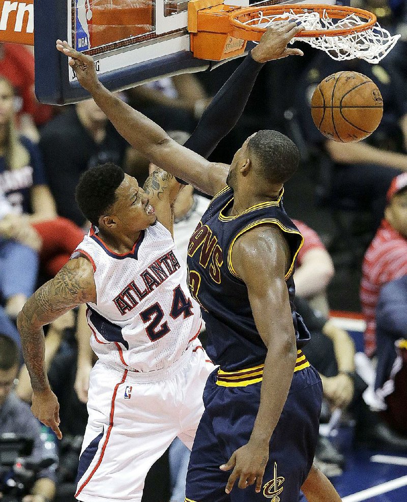 Atlanta guard Kent Bazemore (24) gets by Cleveland’s Tristan Thompson for a second-half dunk Wednesday in the Cavaliers’ 97-89 victory in their NBA Eastern Conference final in Atlanta.