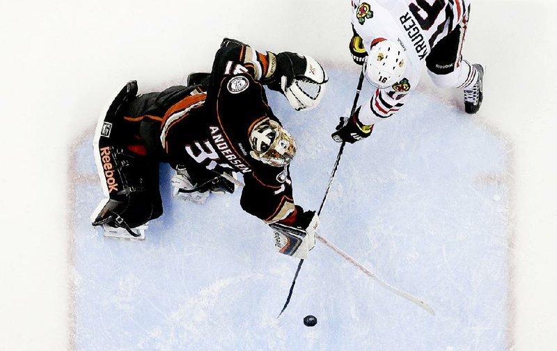 Chicago center Marcus Kruger (right) scores the game-winning goal past Anaheim goalie Frederik Anderson in the third overtime of the Blackhawks 3-2 victory Tuesday.