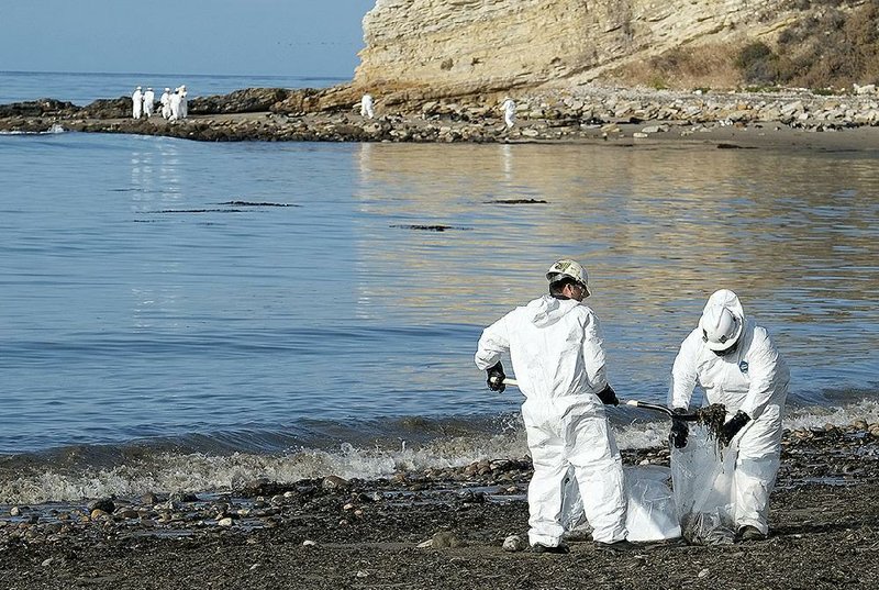 Cleanup workers shovel oil-soaked sand into bags Wednesday at Refugio State Beach in Southern California after an onshore pipeline broke Tuesday. 