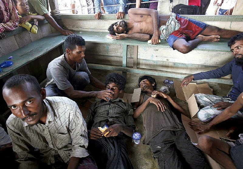 Rescued people rest Wednesday as they are given food and drink after arriving in Simpang Tiga in Indonesia’s Aceh province.