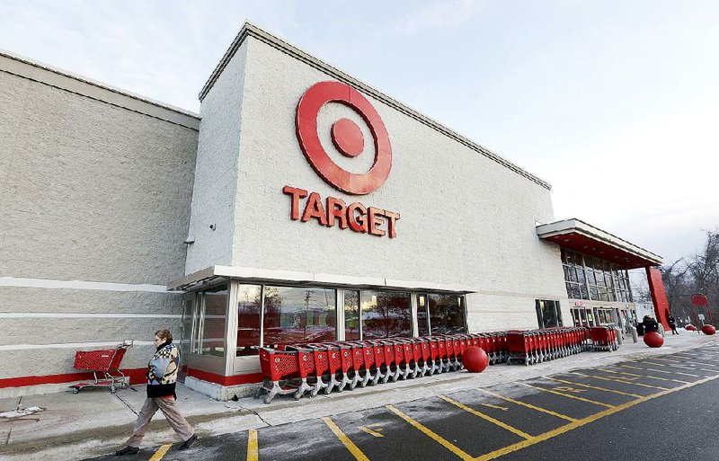 A passer-by walks near an entrance to a Target store in Watertown, Mass. in 2013. Target announced Wednesday that revenue at stores open at least year a year rose 2.3 percent in the first quarter.