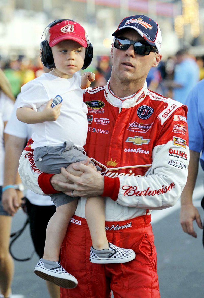 NASCAR Sprint Cup driver Kevin Harvick walks down pit road with his son, Keelan Paul Harvick, before Thursday’s qualifying round for the Coca-Cola 600 at Charlotte Motor Speedway in Concord, N.C.