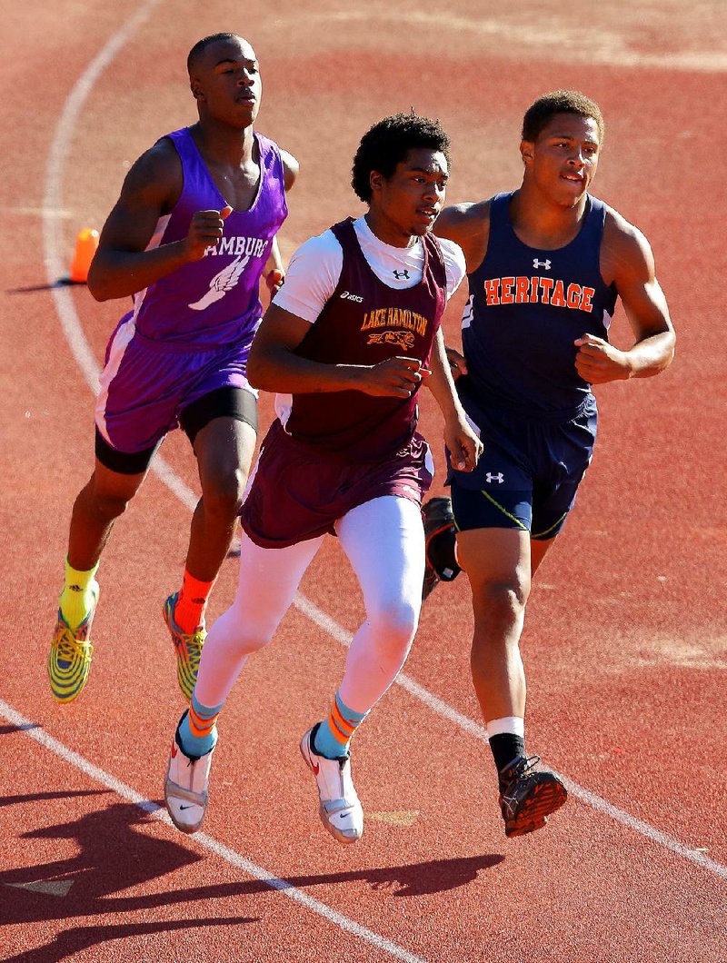 Lake Hamilton’s Donell West (center) leads Rogers Heritage’s Joey Saucier (right) and Hamburg’s Lorenzo Watkins around a turn during the 1,500 meters Thursday at the state high school decathlon at Cabot High School. Saucier fi nished first, West second and Watkins third overall in the decathlon.