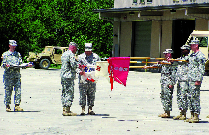 Lt. Col. Shane Mitchell (left), commander of the Arkansas National Guard’s 142nd Field Artillery’s 217th Brigade Support Battalion and Command Sgt. Maj. David Scroggins prepare to encase the flags of the battalion’s Alpha and Bravo companies in a flag retirement ceremony Thursday at Fort Chaffee. 