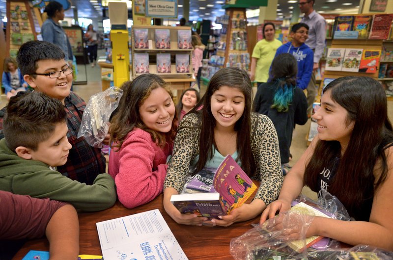 NWA Democrat-Gazette/BEN GOFF Guillermo Olvera (from left), Emanuel Figueroa, Melanie Aldaco, Berenice Sosa and Evelyn Garcia, all fifth-graders from Russell D. Jones Elementary School in Rogers, read from the books Thursday they picked out while shopping with their &#8216;Reading Buddies&#8217; at the Barnes &amp; Noble in Rogers. General Mills employees who have volunteered as reading buddies, visiting students from two fifth-grade classes at the school once a month, met with their students for the last time on Thursday to help them pick out books for summer reading.