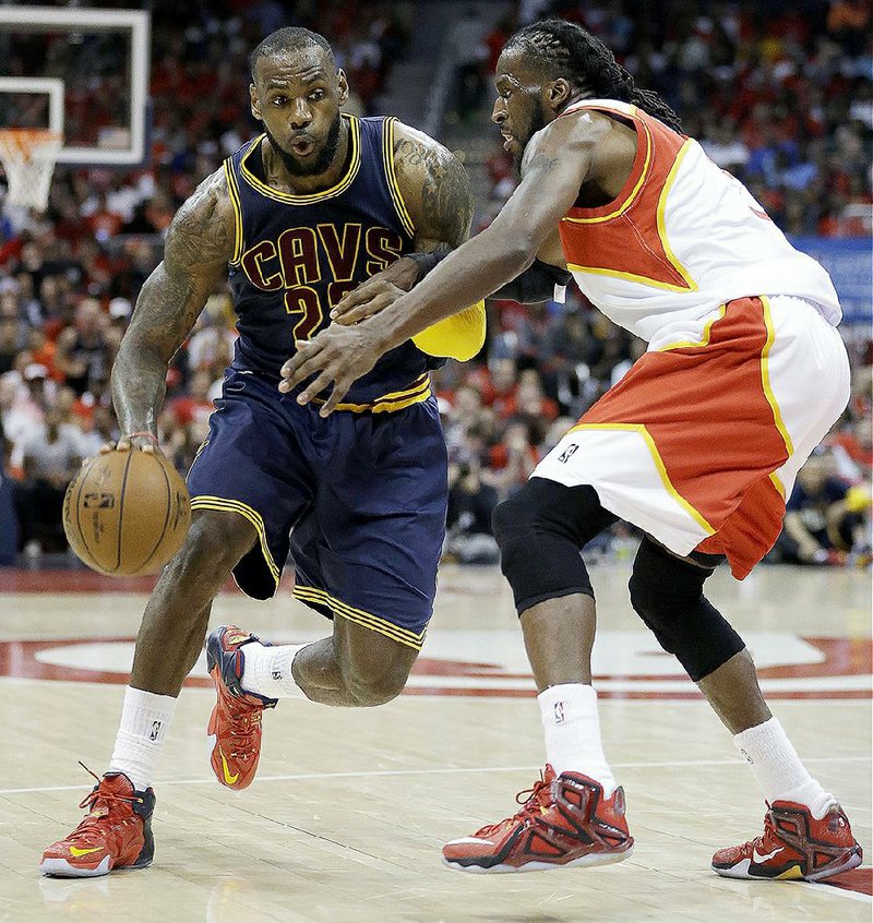 Cleveland forward LeBron James (left) tries to get around Atlanta defender DeMarre Carroll in the second half of Friday’s game. James had 30 points and 11 rebounds in the Cavaliers’ 94-82 victory.