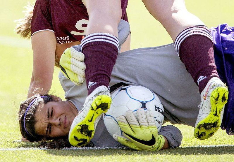 Central Arkansas Christian goal keeper Josie Bates covers the ball as Gentry’s Brieann Ward tumbles over her during Friday’s Class 4A girls soccer final at Razorback Field in Fayetteville.