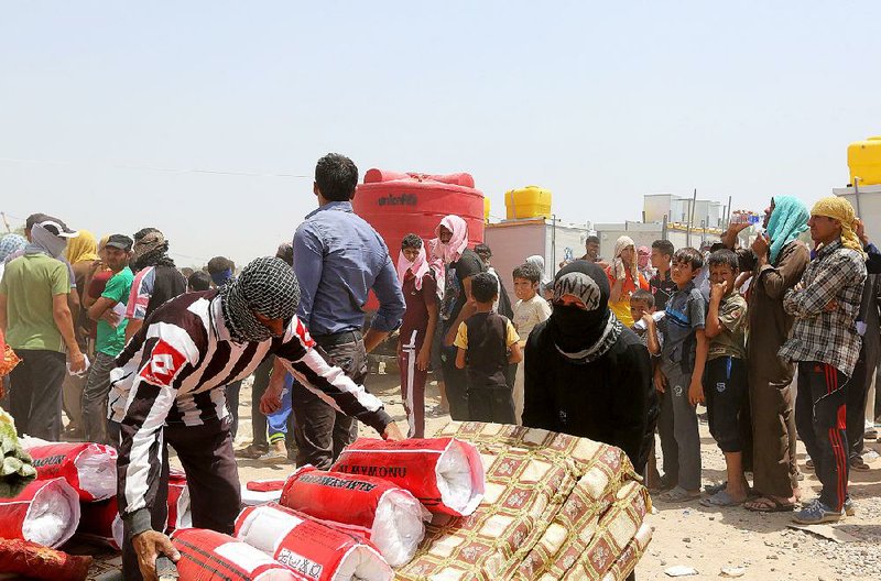 Displaced civilians from Ramadi receive humanitarian aid from the United Nations in a camp in the town of Amiriyat al-Fallujah, west of Baghdad, Iraq, on Friday. 