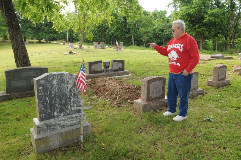 NWA Democrat-Gazette/FLIP PUTTHOFF Rocky Eldred of Bella Vista shows the gravesites of relatives Friday at the Grand Army of the Republic cemetery in Sulphur Springs. Eldred was helping get the cemetery spruced up for a service on Memorial Day.