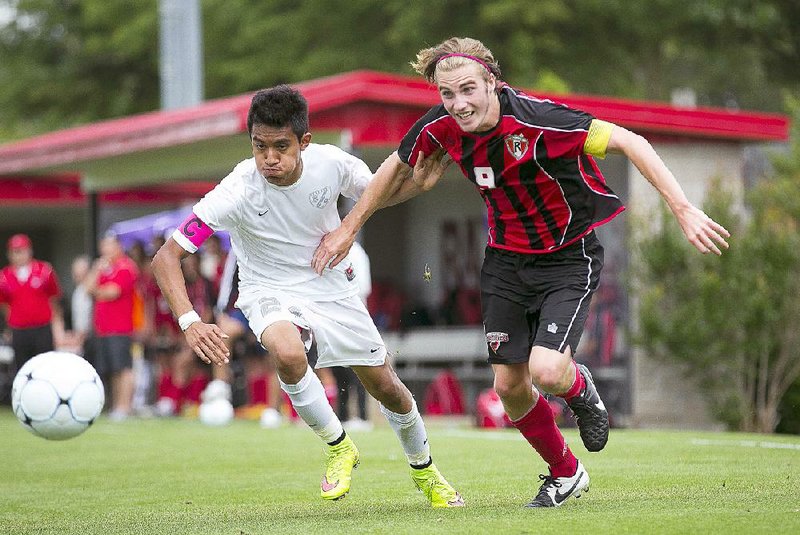Russellville’s Taylor Allen (right) and Siloam Springs’ Edwin Ramirez chase down the ball during the Class 6A boys soccer state championship game Saturday at Razorback Field. Allen scored two goals en route to winning MVP honors while leading the Cyclones to a 2-1 victory and their second consecutive title. See more photos at arkansasonline.com/galleries