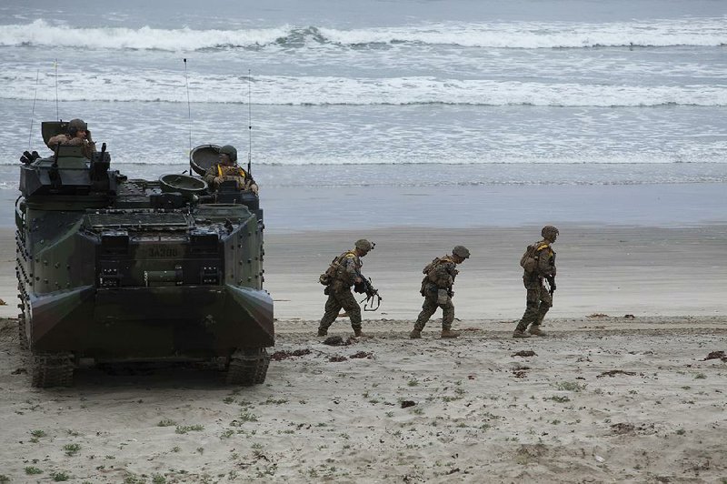Marines leave an amphibious assault vehicle during a joint exercise with Japanese troops at Camp Pendleton, Calif., in 2014. The Marines practice limited live-fire beach assaults at Pendleton, near San Diego, and at Camp Lejeune, N.C., but officials say only the island of Pagan has beaches large enough for major amphibious maneuvers.
