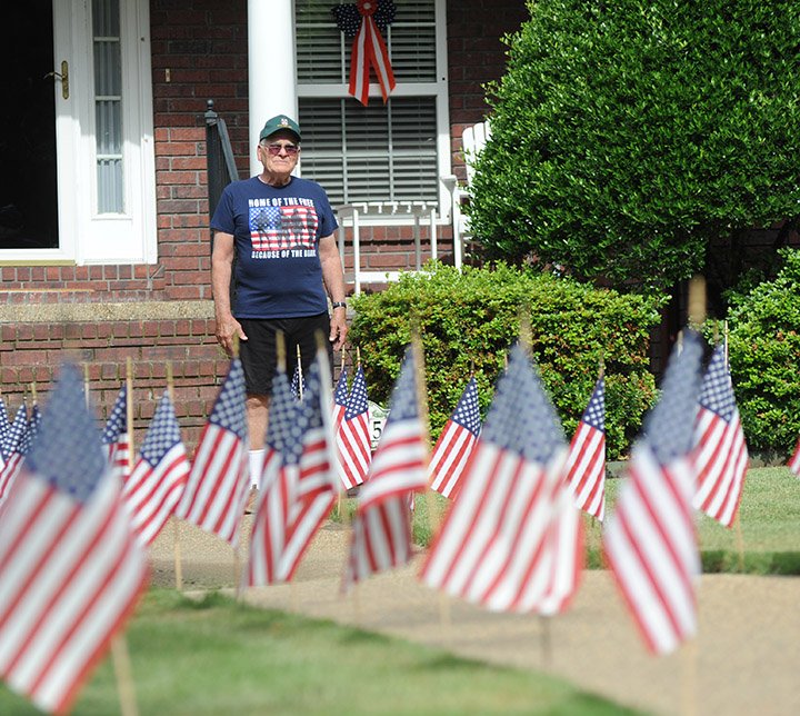 The Sentinel-Record/Mara Kuhn Jim Carden, of Hot Springs, stands among the nearly 200 American flags he placed in his yard on St. Charles Circle. Carden, who served 35 years in the U.S. Army Medical Corps and in Korea, said Saturday that he is displaying the flags to commemorate Memorial Day.