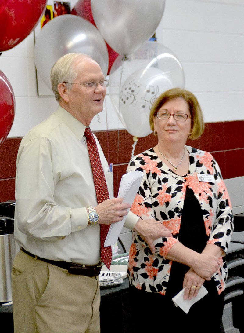 Janelle Jessen/Siloam Sunday Superintendent Ken Ramey presented curriculum coordinator Connie Matchell with a retirement gift. The school district held a reception honoring Matchell and retiring band director Keith Rutledge for their service before the School Board meeting on Tuesday. Matchell has accepted a position as the head of the Department of Teacher Education at John Brown University starting in July.