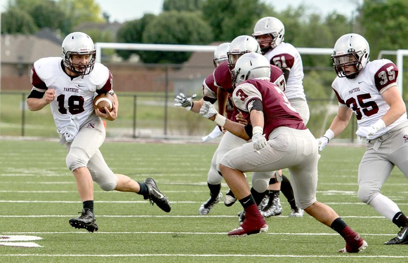 Bud Sullins/Special to Siloam Sunday Siloam Springs Gray junior quarterback Luke Lampton, left, looks for a hole to run through Friday during the annual Maroon-Gray spring football game, while senior Matt Downing, No. 3, defends the play. Lampton had 83 yards rushing and 65 yards passing, but Maroon defeated Gray 22-6 at Panther Stadium.