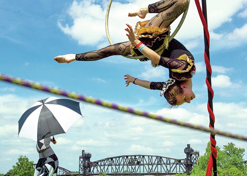Erica Gurley hangs from a hoop while performing aerial stunts Saturday with members of ReCreation Studios and Circus Arts during Riverfest in Little Rock. More photos are available online at arkansasonline.com/galleries. 