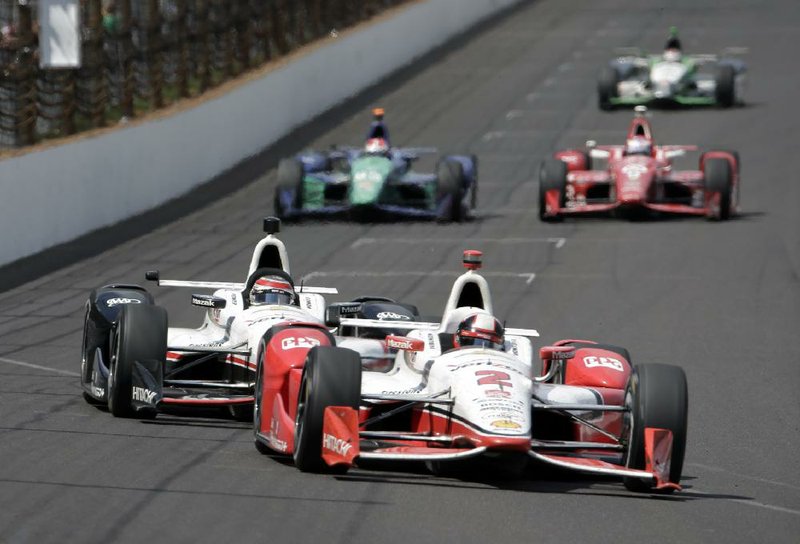 Juan Pablo Montoya (2) leads Will Power into the first turn on the 198th lap during Sunday’s Indianapolis 500 at Indianapolis Motor Speedway. Montoya held off Power to win the race for a second time.