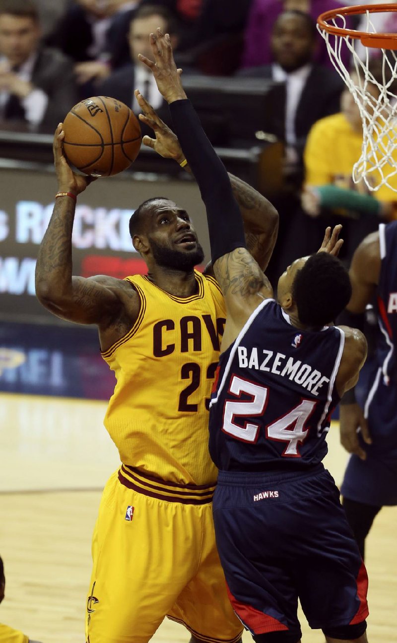 Cleveland guard LeBron James (left) missed his first 10 shots Sunday, but came on to finish with 37 points, 18 rebounds and 13 assists as the Cavaliers beat Atlanta 114-111 in overtime. 