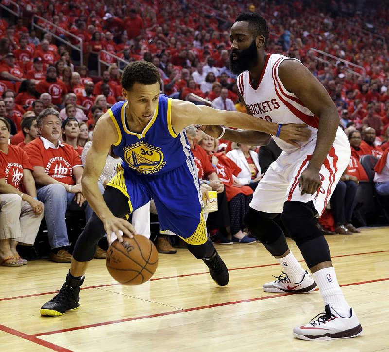 Golden State guard Stephen Curry (30) looks for room along the baseline around Houston defender James Harden during Game 5 of the NBA Western Conference finals on Monday in Houston. Harden scored a game-high 45 points to help the Rockets stave off elimination with a 128-115 victory. Curry finished with 23 points despite suffering a head contusion in the second quarter. 