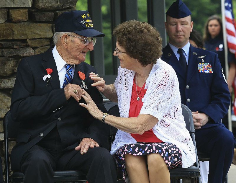 Harold Kindrick and his wife, Melvalea, look at the French Order of the Legion of Honor medal that Kindrick received Monday during the Arkansas Department of Veterans Affairs’ Memorial Day ceremony. Kindrick, a North Little Rock native, served in the Army during World War II and was part of the D-Day invasion of Normandy.