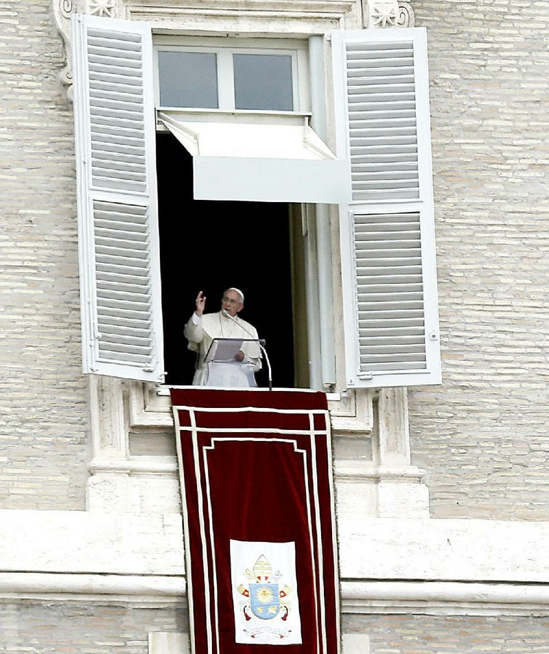 Pope Francis delivers his blessing during noon prayers Sunday from his studio overlooking St. Peter’s Square at the Vatican. The pope will address the U.N. General Assembly on Sept. 25 when he visits the U.S., soon after releasing his encyclical on climate change and the environment. 