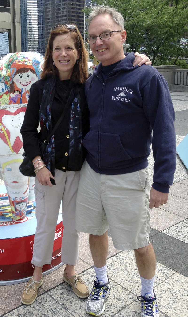 In this July 2014 photo provided by Karen Friend, Friend, left, stands with her husband, Jacob Vinton, on Michigan Avenue in Chicago. Friend, a professor at Brown University in Providence, R.I., took four weeks off in 2014 after her 59-year-old husband, who has early-onset Alzheimers disease, was hospitalized with tremors. S