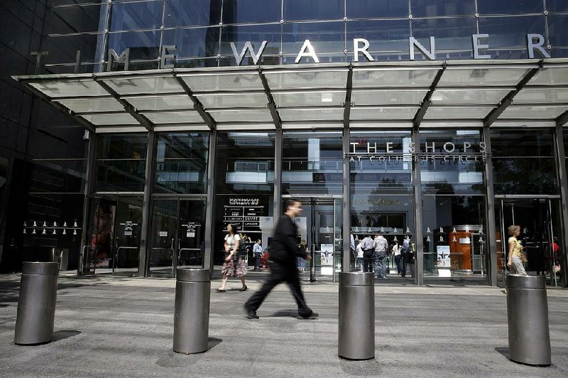 Pedestrians pass the Time Warner Center, home of the headquarters of Time Warner Cable, on Tuesday in New York. 
