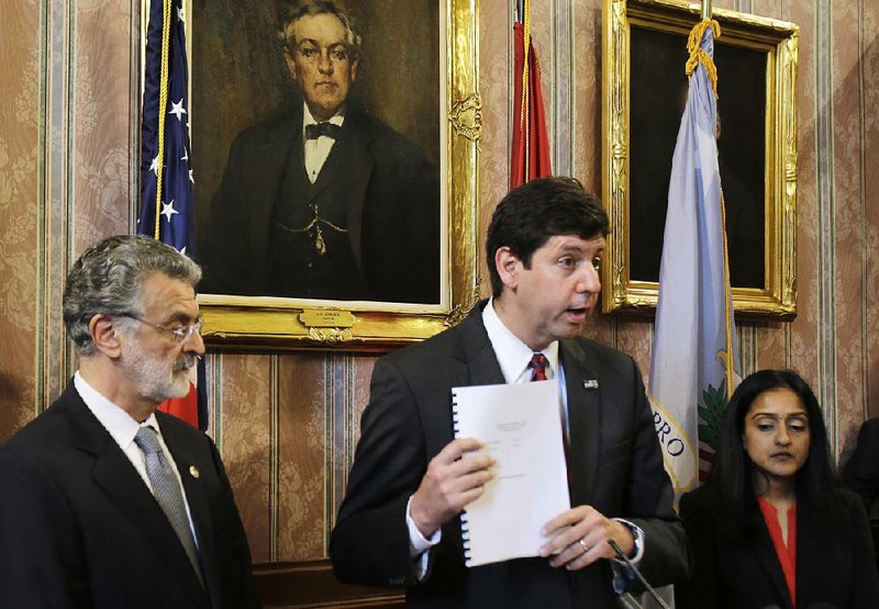 U.S. Attorney Steven Dettelbach, flanked by Cleveland Mayor Frank Jackson (left) and head of the Civil Rights Division at the Department of Justice Vanita Gupta (right), holds up the settlement agreement with the city of Cleveland as he addresses a news conference Tuesday in Cleveland.