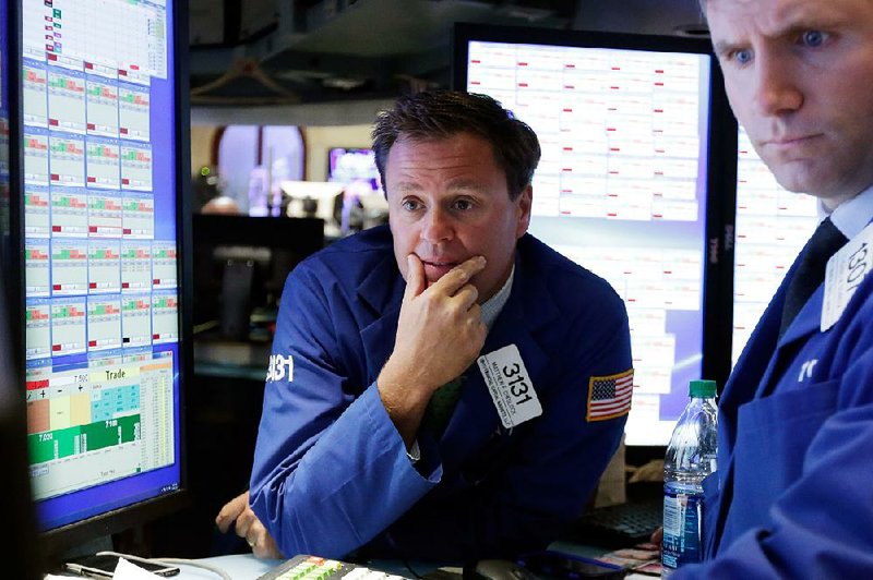 Specialist Matthew Cheslock (left), works Tuesday on the floor of the New York Stock Exchange.