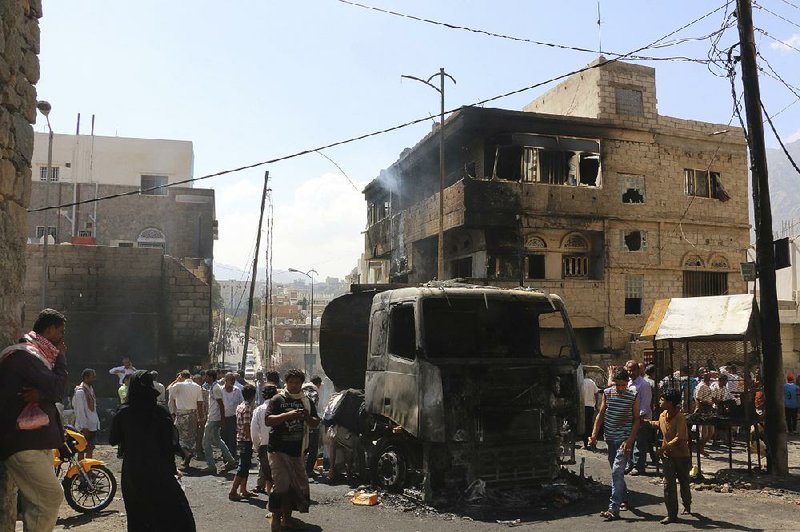 People gather around a truck carrying oil that was hit by crossfire between fighters loyal to the exiled President Abed Rabbo Mansour Hadi and Shiite rebels in Taiz city, Yemen, on Monday. Military officials said about 10 civilians died and some 200 others were wounded after the truck was hit by gunfire and burst into flames. 