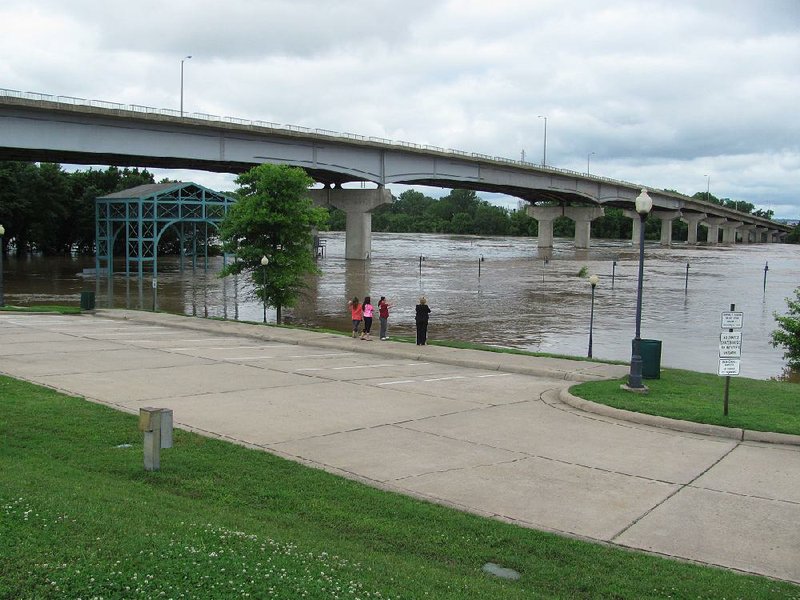 The Arkansas River flows above flood stage Tuesday at the Garrison Avenue bridge between Fort Smith and Oklahoma. The river crested at 33.2 feet Tuesday in Fort Smith, 11 feet above flood stage. 