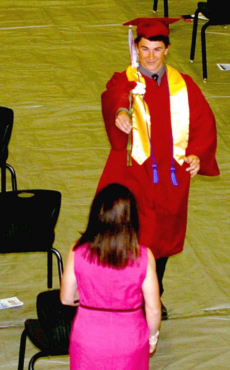 MARK HUMPHREY ENTERPRISE-LEADER Alec Pitts beams widely while presenting a flower to his mother, Guatha Pitts, during Lincoln&#8217;s graduation celebration on Thursday.