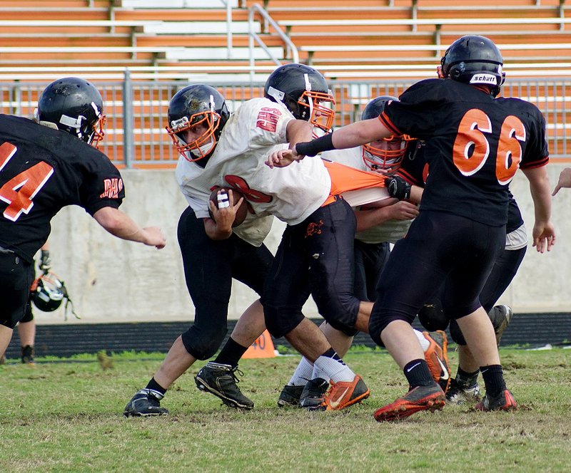Photo by Randy Moll Jordan Burnett, carrying the ball for the white team, is grabbed by the jersey from behind during the orange and white game in Gravette on Thursday.