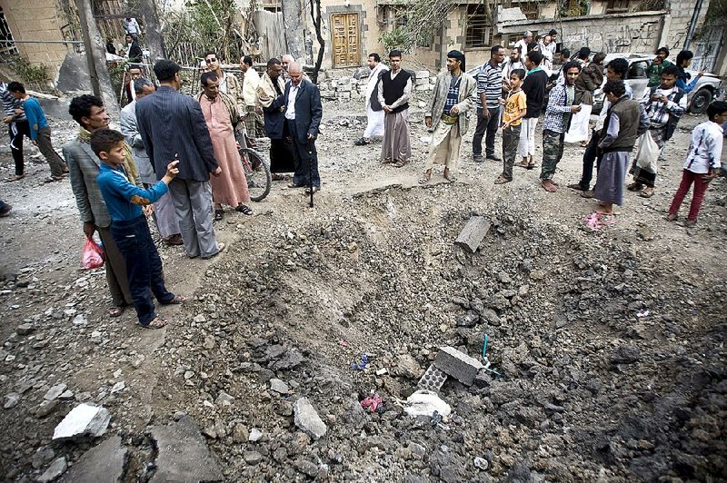 People in Sanaa, Yemen, gather around a crater Wednesday after deadly Saudi-led airstrikes blasted parts of the city and other sites in the country. 