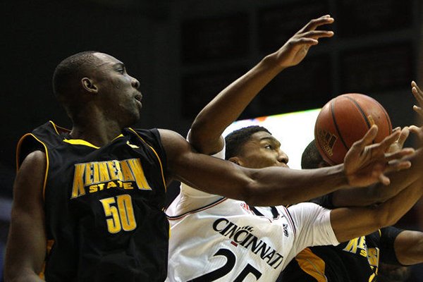 Kennesaw State center Willy Kouassi battles Cincinnati guard Kevin Johnson for a rebound on Friday, Nov. 29, 2013, at Fifth Third Arena in Cincinnati. (AP Photo/David Kohl)