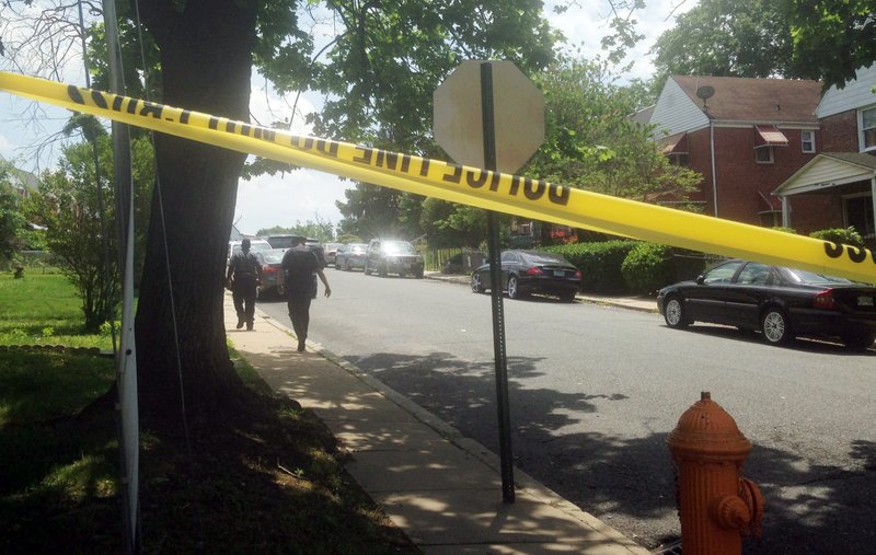A Baltimore Police officer follows a man, who screamed "Let me in! I'm going in!" before crossing the yellow tape and walking into the crime scene on the 100 block of Upmanor Road, in Baltimore, where a young boy and a 31-year-old woman were shot and killed, Thursday, May 28, 2015. In the month since Freddie Gray died and the city erupted in civil unrest, Baltimore has seen its murder rate skyrocket. There have been 36 murders in May alone.