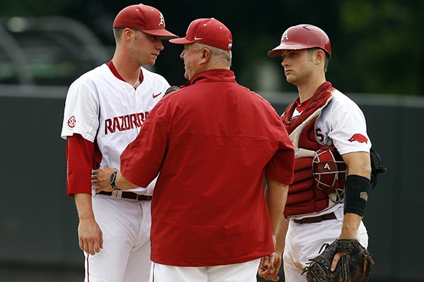 Arkansas pitching coach Dave Jorn, center, talks with starting pitcher Trey Killian and catcher Tucker Pennell in the first inning of a game against Oral Roberts at the Stillwater Regional of the NCAA college baseball tournament in Stillwater, Okla., Friday, May 29, 2015. (AP Photo/Sue Ogrocki)