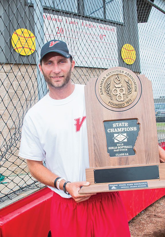 Vilonia girls softball coach Kevin Sullivan holds the Class 5A State Championship trophy his team won this year, after coming in as the runner-up a season ago. The Lady Eagles defeated Paragould 5-2 after Vilonia senior Buggy Lyons hit a three-run homer.