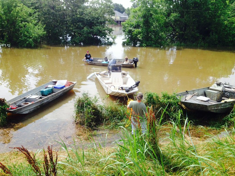 Residents of Island Harbor Estates in Pine Bluff travel to and from their homes by boat Friday morning, May 29, 2015.