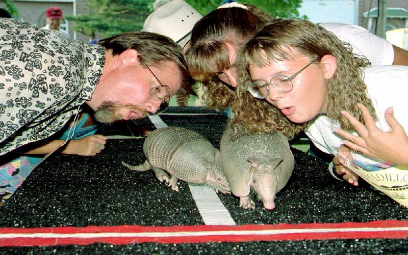 Joe Hackley of Gillett and his daughters, Harper (center) and Leigh, sing “The Armadillo Song” to the ’Dillo Supper mascots Amos (left) and Andie.
