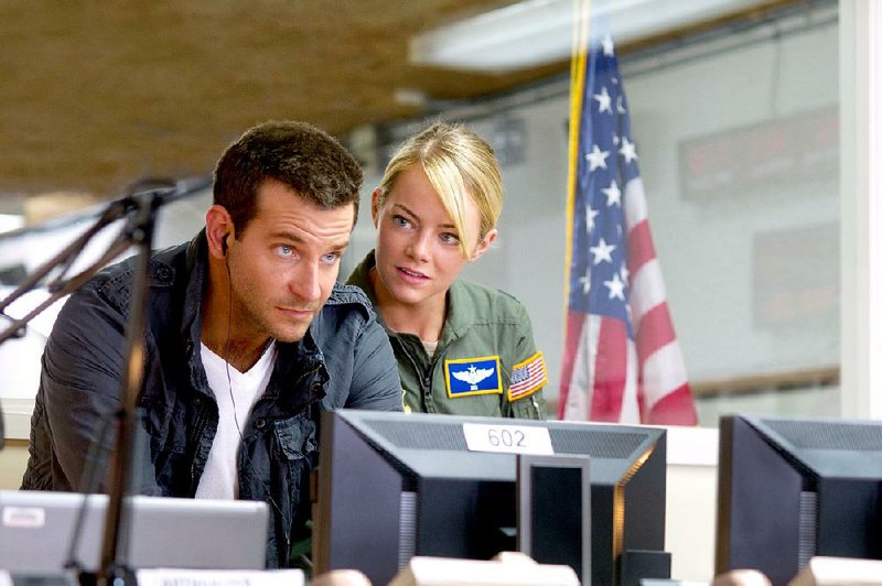 Military contractor Brian Gilcrest (Bradley Cooper) is closely watched by Air Force Capt. Allison Ng (Emma Stone) in Cameron Crowe’s island-set romantic comedy Aloha.
