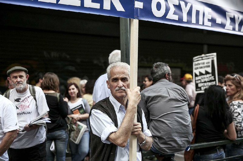 A man holds a banner during a protest rally Thursday outside the Ministry of Employment in Athens, Greece. Greek government officials said they expect to reach a deal with creditors by Sunday. 